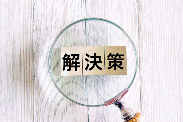 解決策と書かれた木のブロックと虫メガネ